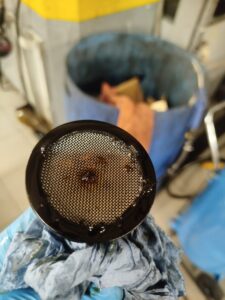 Motorschade bij Citroën C3 door versleten distributieriem waarbij rubberresten de oliezeef verstoppen, met risico op totale motorbreuk.