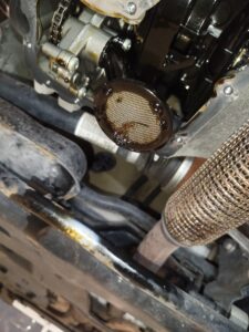 Motorschade bij Citroën C3 door versleten distributieriem waarbij rubberresten de oliezeef verstoppen, met risico op totale motorbreuk.